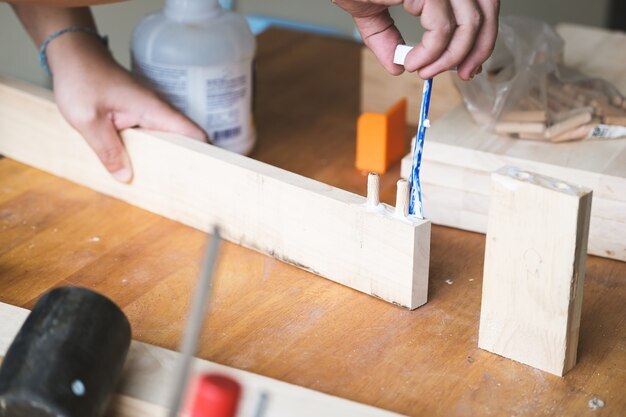 Hand brushing glue on dowel pins